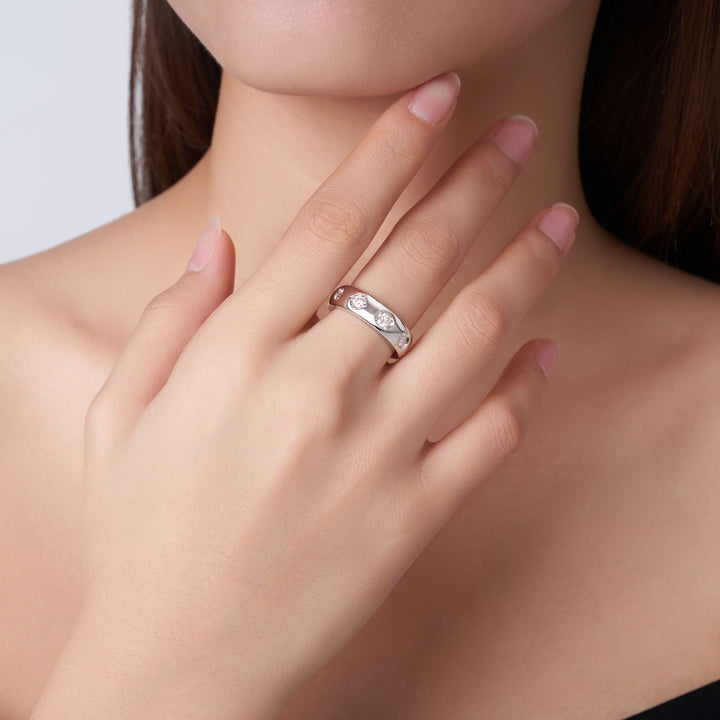 Silver ring on a finger with a neutral background