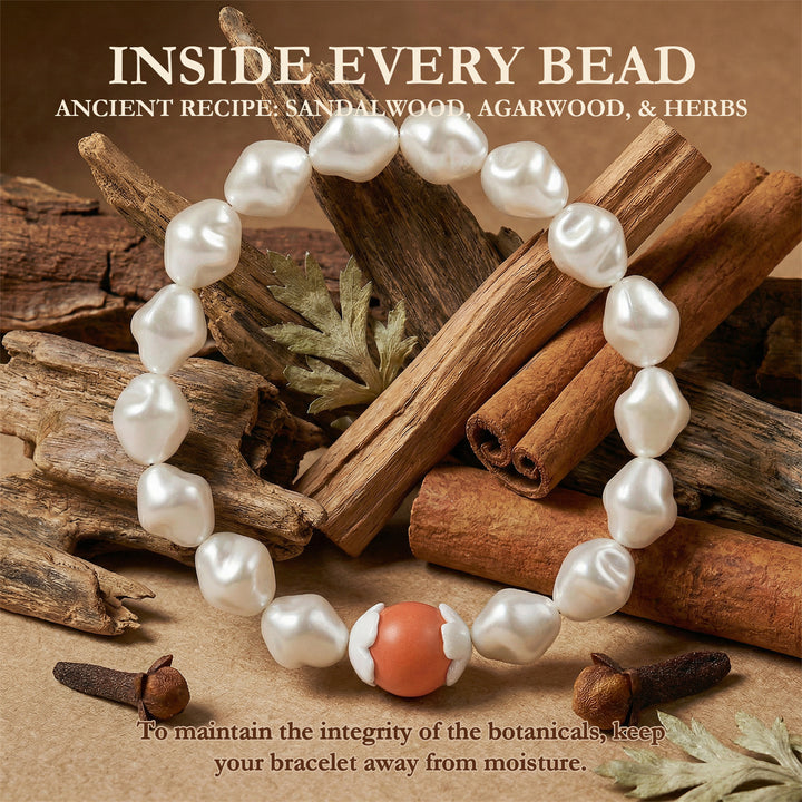 Pearl bracelet with a central coral bead on a background of sandalwood, agarwood, and herbs.