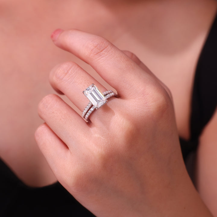 Close-up of a hand wearing a diamond ring with a baguette-cut center stone.