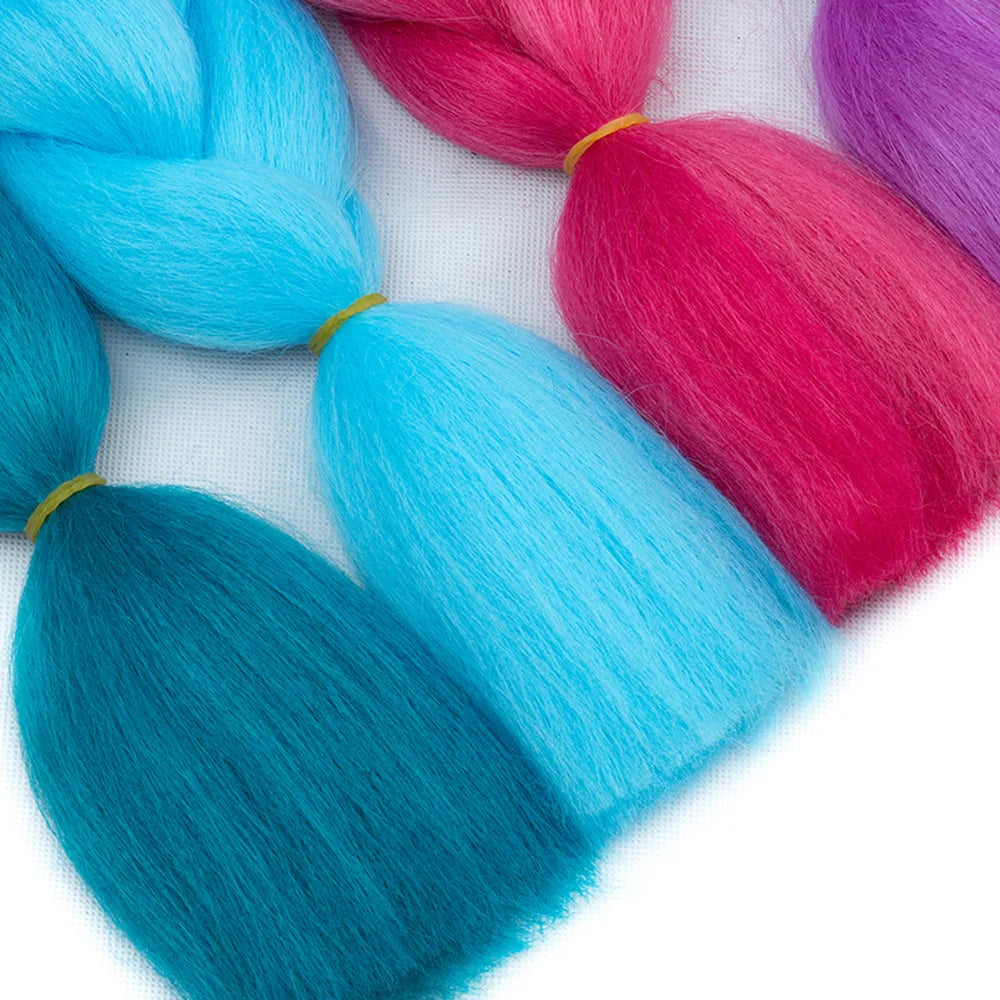 Turquoise, pink, and purple braided hair extensions on a white background