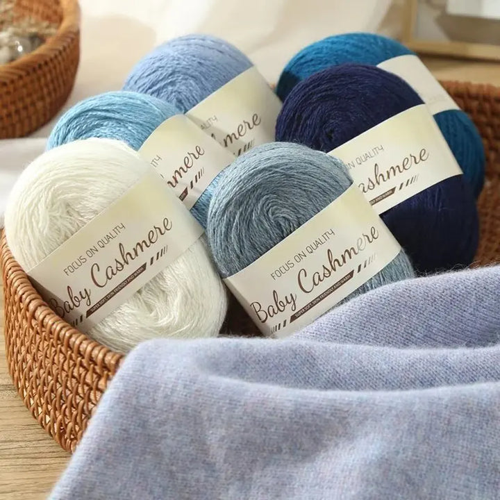 Basket of baby cashmere yarn in various colors with visible labels.