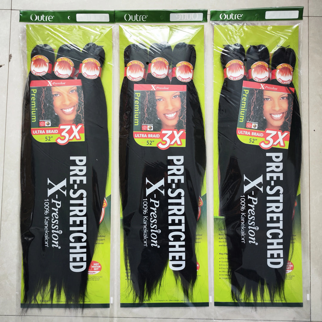 Three packages of Outre X-Pression pre-stretched hair extensions on a gray background.