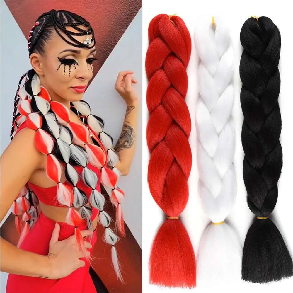 Woman with styled hair and three braided hair extensions in red, white, and black.