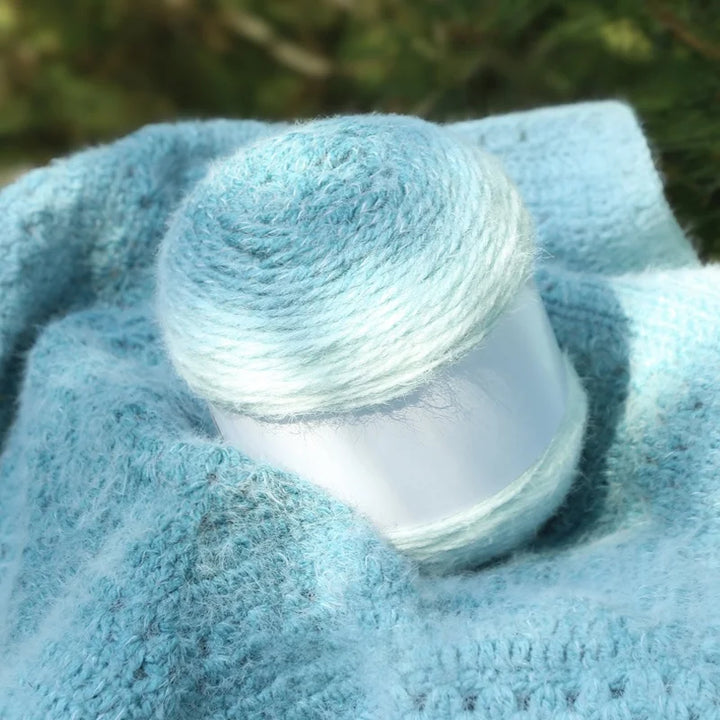 Ball of yarn on a blue towel with a blurred natural background