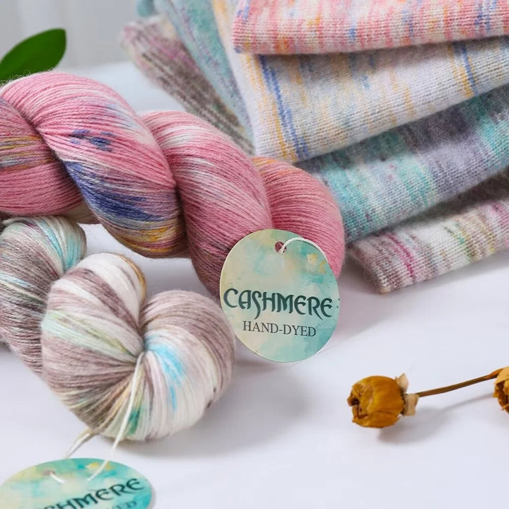 Hand-dyed cashmere yarn with a visible brand tag on a white background