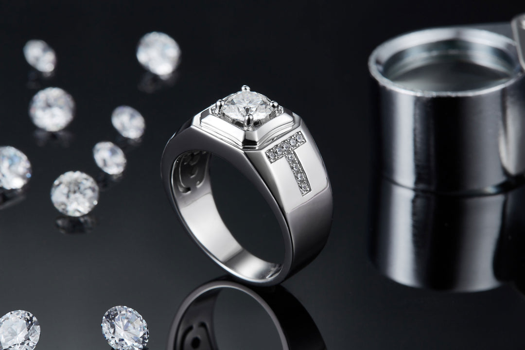 Silver ring with a large diamond and smaller diamonds on a reflective black surface