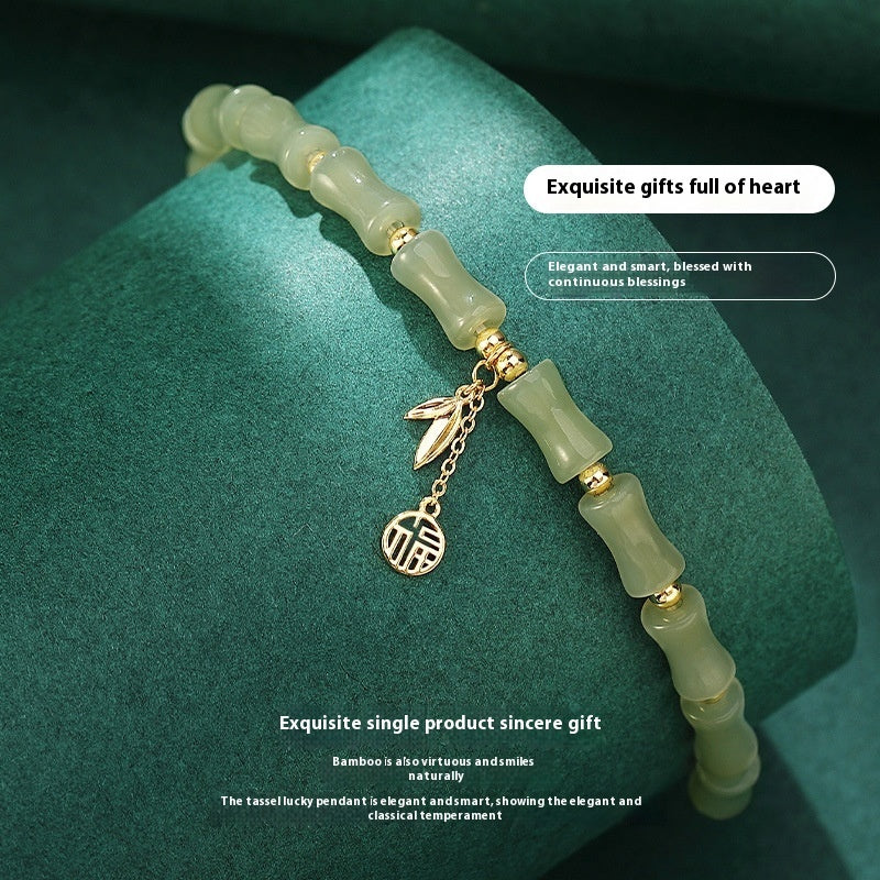 Green jade bracelet with gold accents on a green background
