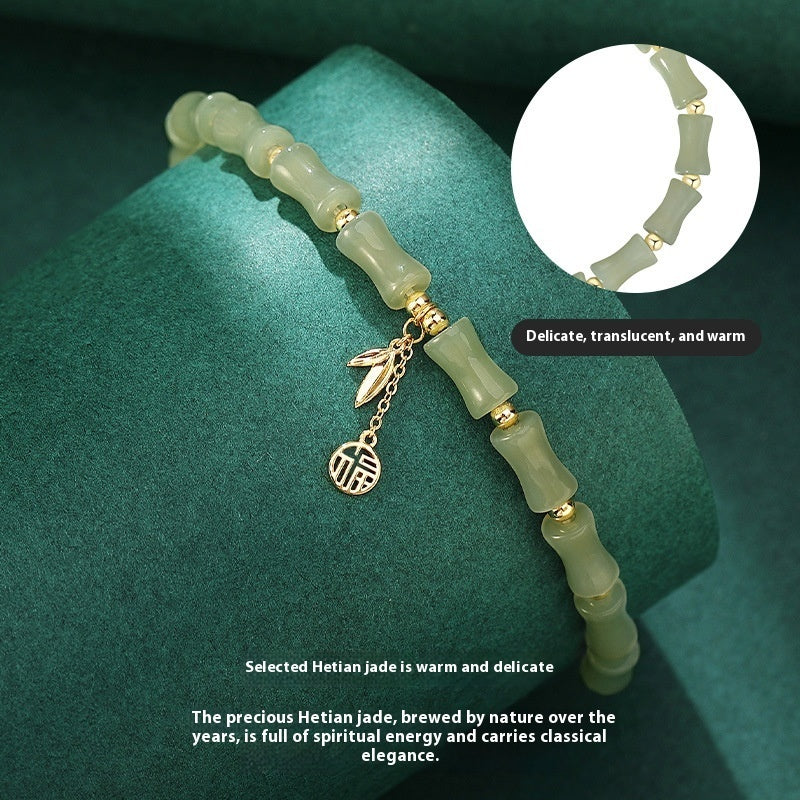 Green jade bracelet with gold charms on a green background
