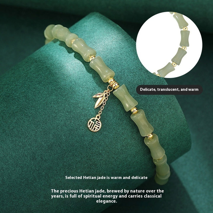 Green jade bracelet with gold charms on a green background