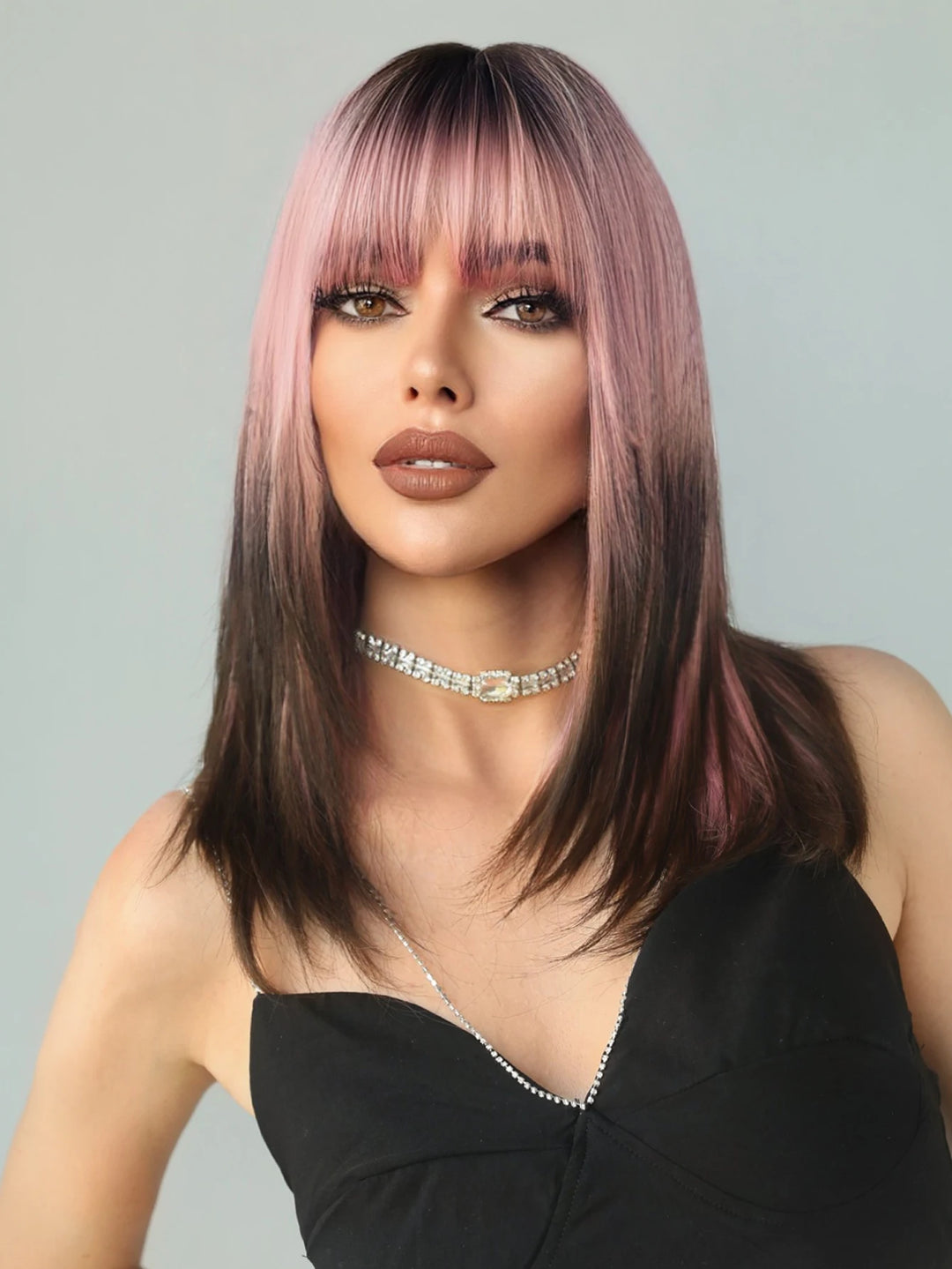 Pink and brown ombre wig with bangs for women. Great for cosplay, Christmas parties, and other events. Made of synthetic material.