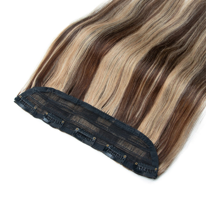 Brown and blonde hair extensions with a black clip on a white background