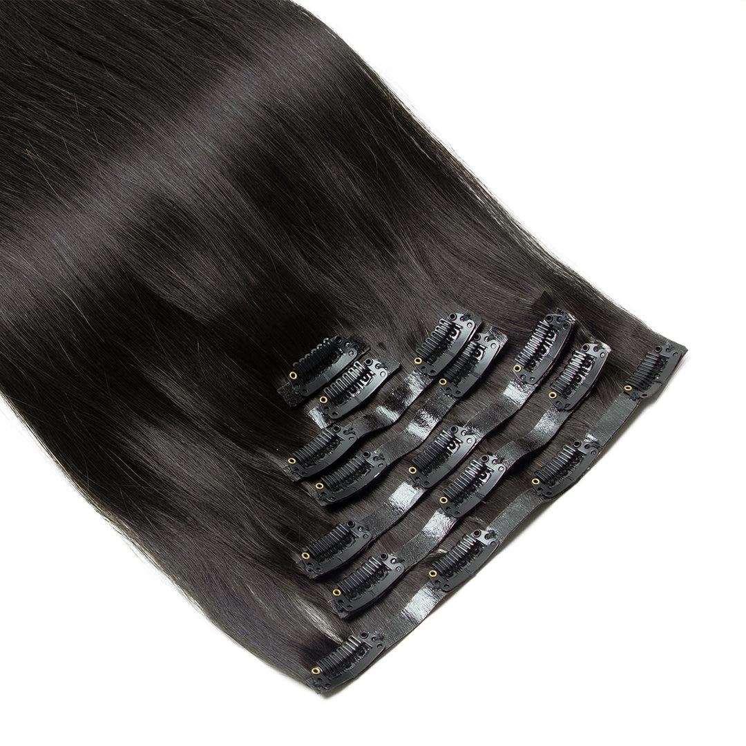 Set of black hair extensions with clips on a white background