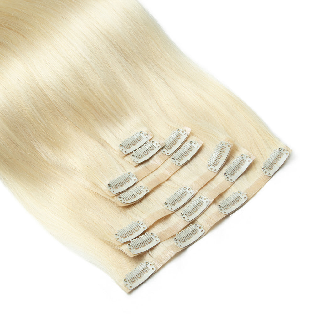 Blonde hair extensions with clips on a white background